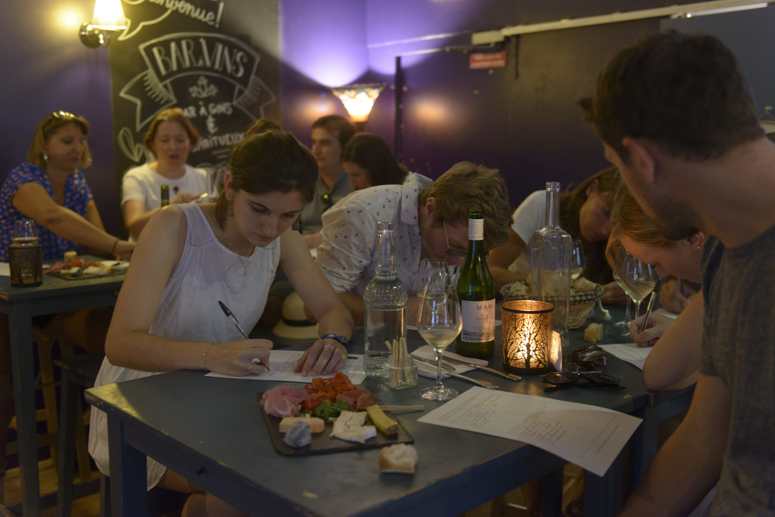 Des visiteurs prennent l'apéro en donnant leurs retours à l'écrit.
